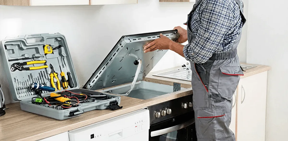 Handyman repairing a cooktop and checking wiring connections in Kansas City, MO