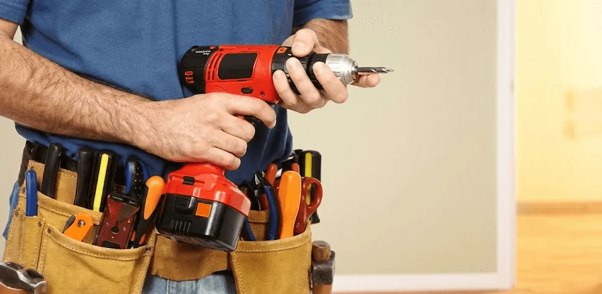 Handyman holding a power drill for home repairs and installations in Kansas City, MO